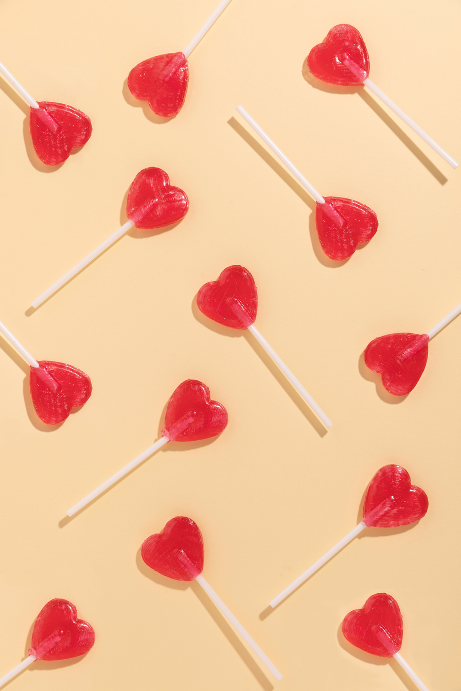 Heart-Shaped Lollipops on Yellow Background